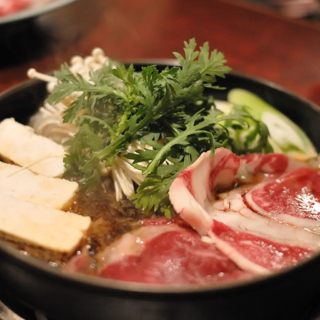 Sukiyaki simmering in an iron pot.